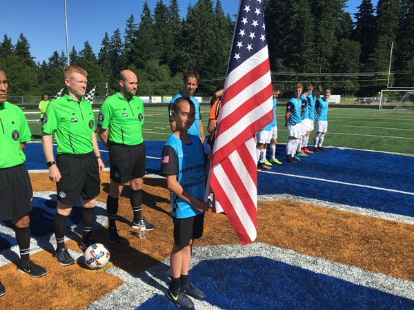 Kysho Barnhill holding the American flag for the Pledge of Allegiance.